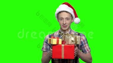 带礼物盒和圣诞帽的少年。