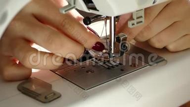 缝在缝纫机上.. 一个修指甲的女人加强了针中的线。