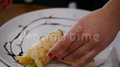 女人的手紧紧地`在煎饼上放馅。 在木制<strong>圆桌</strong>上烹制国家美食