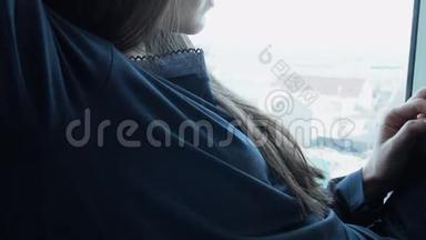 一个甜美的，年轻的女人正在等待她心爱的家，坐在窗户上。 一位美丽的年轻女子坐在窗户上
