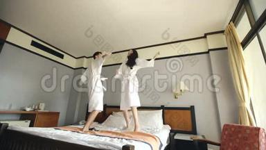 新婚夫妇在蜜<strong>月度</strong>假期间在酒店的床上跳着浴袍跳舞
