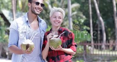 情侣饮料椰子<strong>鸡尾</strong>酒会在棕榈树上交谈，快乐男人和女人微笑游客交流