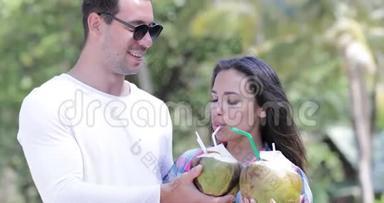 情侣饮料椰子<strong>鸡尾</strong>酒会在棕榈树上交谈，快乐的微笑男人和女人游客交流