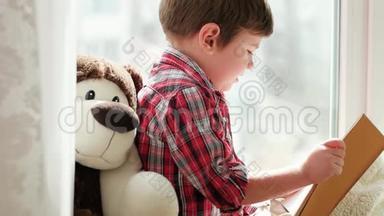 小孩子在家看书，聪明的孩子坐在窗户上，带着毛皮看童话故事