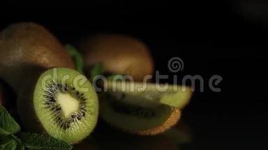 美味多汁的水果猕猴桃和薄荷放在黑桌上。 从桌子上反射猕猴桃。 高清。
