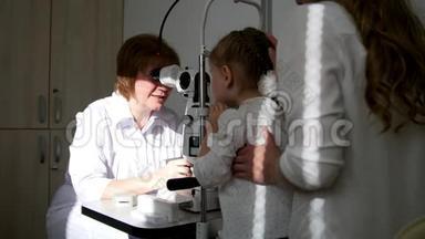 一个可爱的金发小女孩，妈妈在儿童`眼科-验光师诊断视力