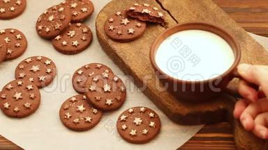 旧木工切割板上的粘土杯中的<strong>热牛奶</strong>和新鲜的烤巧克力饼干