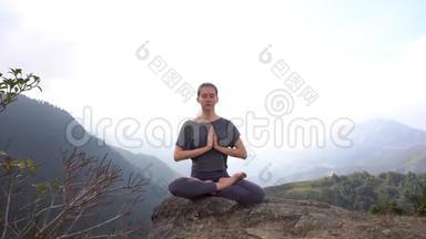 越南萨帕山崖上坐坐冥想姿势的瑜伽女人