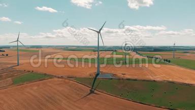 风轮机和风力发电机在<strong>夏季</strong>的一<strong>天</strong>在大片开阔<strong>天</strong>空的小麦作物上运行的鸟瞰图