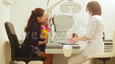母亲和女儿在眼科医生的房间`验光师在诊所检查小孩`视力