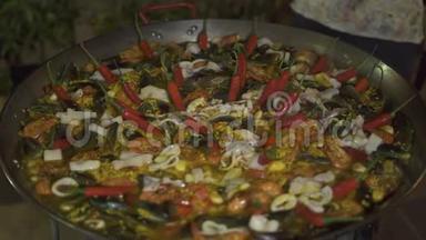 用红辣椒和新鲜海鲜在锅里煮西班牙海鲜饭。 西班牙传统食品海鲜饭