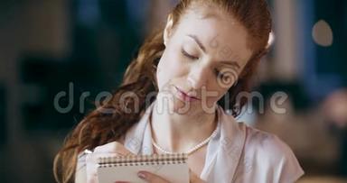 红头发的女人写着记事本的肖像。 企业业务团队工作<strong>办公会议</strong>.. 高加索商人和