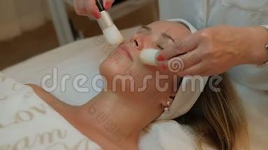 美容师两把刷子在女人的脸上做按摩`眼睛紧闭。