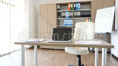 一台现代化的笔记本电脑，放在一间现代化的空办公室的桌子上