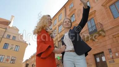 两个旅游女孩正在老城区用手机拍照自拍