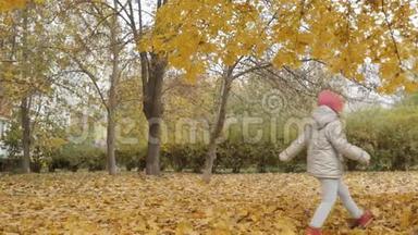 小女孩在秋天公园的黄叶上奔跑