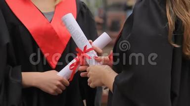 戴着红丝带毕业证书的女毕业生的手，谈话