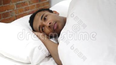 躺在床上思考和想象夜晚的非洲男人