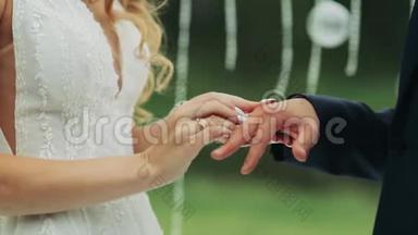 新婚夫妇在夏日阳光明媚的户外举行婚礼时戴上结婚戒指