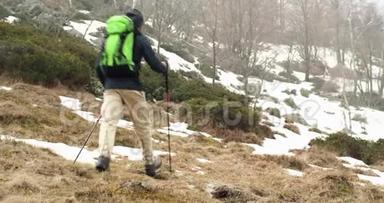 徒步旅行者背着背包走在雪地小径上。 在前面。 真正的背包客，成人徒步旅行或徒步旅行