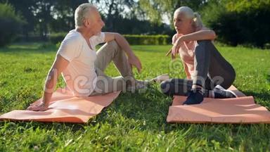 快乐的老年运动夫妇坐在运动垫上