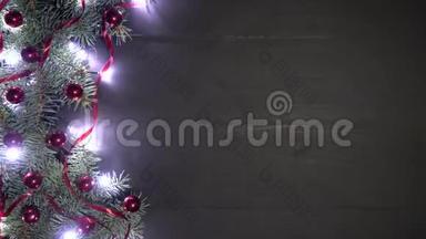圣诞节背景的黑木装饰杉树枝。 松树上装饰着黄柏、红纸屑和闪闪发光的灯光