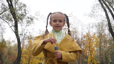 阴天时，穿着黄色外套的小女孩在公园里吹气泡