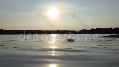 夕阳西下，一只稚气的纸船在林湖中漂浮