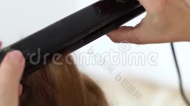 理发师用发钳把头发<strong>卷起</strong>来。 在美容工作室用熨斗加工卷发长发。 嗜血杆菌