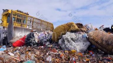 一辆垃圾填埋场的卡车在垃圾填埋场移动大大小小的垃圾。