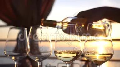 把美味的白葡萄酒倒入玻璃杯中，杯中有夕阳和大海的倒影。 高清，1920x1080。 慢动作