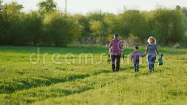 一对农民正沿着一条风景如画的乡村道路行走。 带着他们的小儿子。 去种树，带一棵