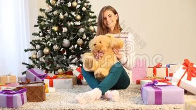 漂亮的女孩坐在玩具熊和礼物