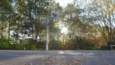 秋天的篮球场和镜头弗莱。 相机从左边。 篮球出现在图片中。