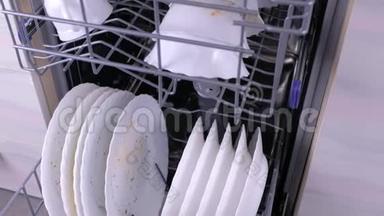厨房<strong>洗碗机</strong>篮子里的脏白色盘子。