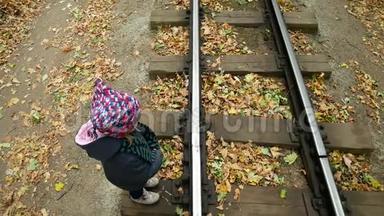 小<strong>女孩</strong>整齐地穿过铁路。 从顶部的视频。