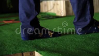 男人踩着绿色的门垫。 男人穿着袜子`绿色地毯上