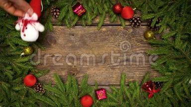 女人`手创造圣诞装饰。 圣诞树上的树枝，木纹上有圆锥和圣诞装饰