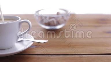 在木桌上倒入<strong>咖啡杯</strong>的奶油