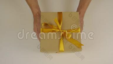 双手伸展一个礼盒，用金色丝带绑着蝴蝶结.. 赠送礼物。 双手捧着礼盒祝贺