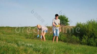 两名志愿者，一男一女，在靠近森林的草地上<strong>清理垃圾</strong>和干树枝