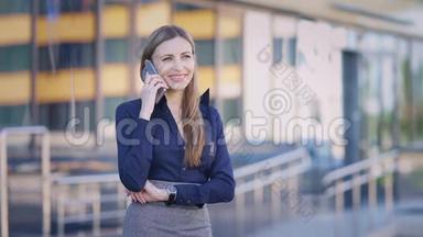 一位忙碌的商务女士正在工作休息期间用手机聊天，这位女士正在和附近的一位同事聊天