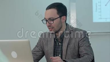 积极的男老师坐在桌旁用手提电脑打字，然后<strong>上课</strong>