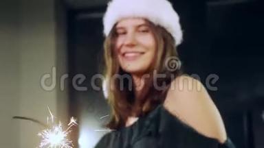 一个女孩模特用手中的火花<strong>许愿</strong>的肖像。 圣诞帽。 圣诞女孩。 看着摄像机
