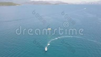 在蓝海湾无人驾驶飞机视野中带伞的帆船。 在绿松石海中滑翔伞航行的空中景色
