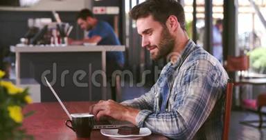 在咖啡厅工作的人在笔记本电脑和接听电话