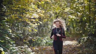 年轻活跃的女运动员锻炼户外秋季公园。 女孩微笑，头<strong>发挥</strong>舞，健康的女人，慢动作