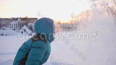 一个孩子在<strong>冬天户外</strong>玩耍，把雪扔到顶部。 积极的<strong>户外运动</strong>。 日落