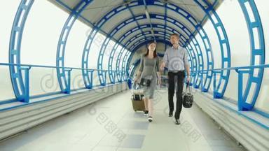 商业伙伴-一男一女在车站或机场的终点站携带行李。 出差，团队