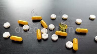 医疗药丸。 黑色桌子上的彩色药丸和胶囊。 药房主题，胶囊丸与药物抗生素在